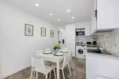 a kitchen and dining room with a white table and chairs at Amazing Oura Beach Apartment in Albufeira