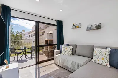 a living room with a couch and a balcony at Amazing Oura Beach Apartment in Albufeira
