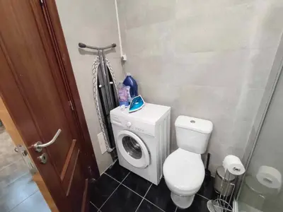 a bathroom with a toilet and a washing machine at Albufeira INN - Vale Navio T2 in Albufeira