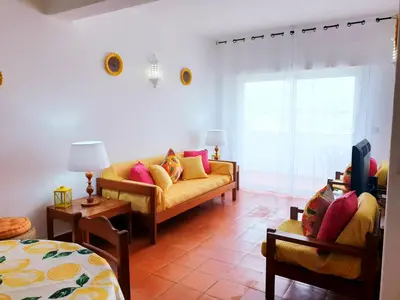 a table with chairs and plates of food on it at Corte Real Apartment O - Sea & Old Town View in Albufeira
