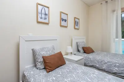a bedroom with two beds and a window at Vacances Tranquilles in Olhos de Água