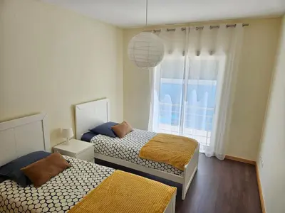 two beds in a room with a window at Vacances Tranquilles in Olhos de Água