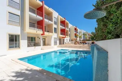 a swimming pool in front of a building at Vacances Tranquilles in Olhos de Água