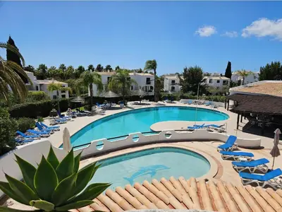 a large swimming pool with lounge chairs and a resort at Apartamento Studio Sao Rafael, 450m Praia in Albufeira