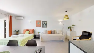 a white room with two beds and a couch at Apartamento Studio Sao Rafael, 450m Praia in Albufeira