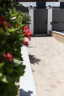 a garden with red flowers on a sidewalk at Silver Globe in Albufeira