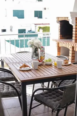 a wooden table with plates of food on a patio at Silver Globe in Albufeira