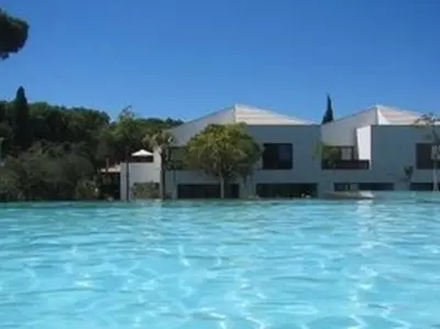 a large pool of blue water in front of a building at Serenity-First villa in Albufeira