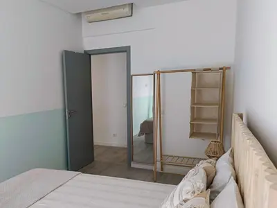 a bedroom with a mirror next to a bed at Grey and Green, modern 2-bedroom apartment, AC, top location at faro's historic centre in Faro