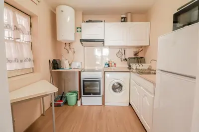 a small kitchen with white cabinets and a washer and dryer at Old Village - Vilamoura T0 com pátio in Bicas