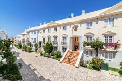 a large white building with stairs in front of it at Old Village - Vilamoura T0 com pátio in Bicas