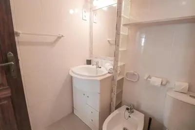 a white bathroom with a toilet and a sink at Old Village - Vilamoura T0 com pátio in Bicas