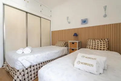 two beds in a room with white sheets at Maison Du Soleil by Seareen in Albufeira