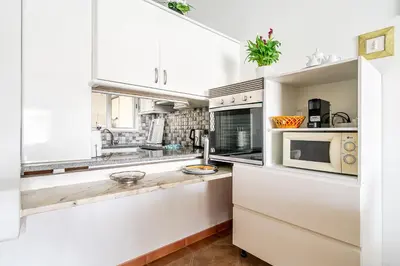 a kitchen with white cabinets and a microwave at Maison Du Soleil by Seareen in Albufeira