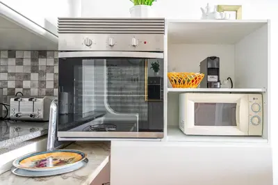 a kitchen with a stove and a microwave at Maison Du Soleil by Seareen in Albufeira