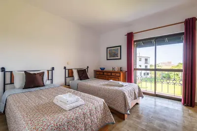 a bedroom with two beds and a large window at Apartamento Sol & Mar by Portucasa in Albufeira