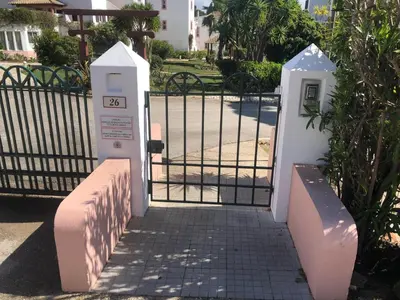 a gate with a parking meter next to a fence at Solar do Golf T1 Vilamoura Old Village in Quarteira