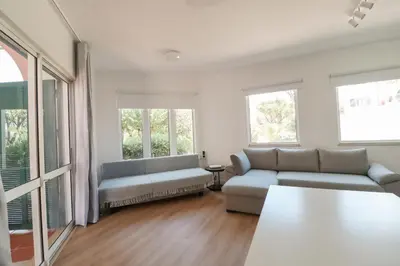 a living room with two couches and two windows at Solar do Golf T1 Vilamoura Old Village in Quarteira
