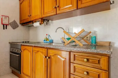 a kitchen with wooden cabinets and a sink and a stove at Maison A Quinta V1 4 Personnes in Ferreiras
