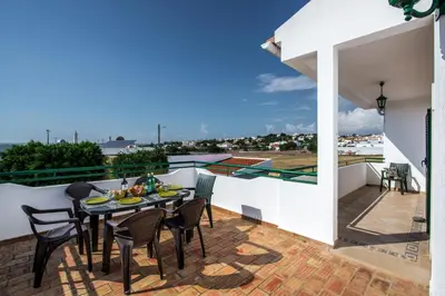 a patio with a table and chairs on a balcony at Rebela 1st Algarve Villa Holidays in Albufeira