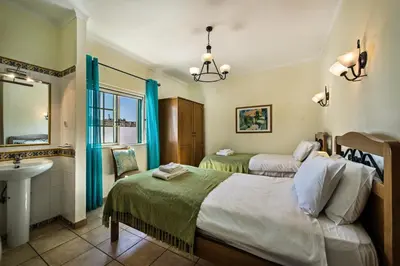a bedroom with two beds and a sink and a mirror at Rebela GF by Algarve Villa Holidays in Albufeira