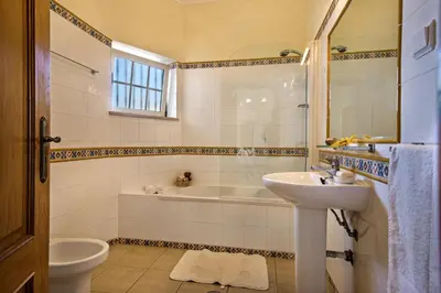 a bathroom with a sink and a tub and a toilet at Rebela GF by Algarve Villa Holidays in Albufeira