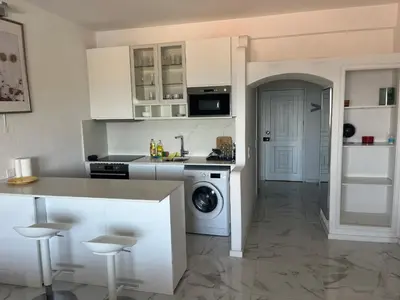 a kitchen with white cabinets and a washing machine at Amazing Sea View Studio w Pool in Albufeira