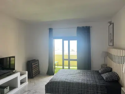 a bedroom with a bed and a sliding glass door at Amazing Sea View Studio w Pool in Albufeira