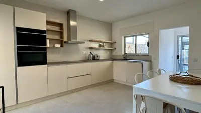 a kitchen with white cabinets and a white table at Cruzeiro by Check-in Portugal in Quarteira