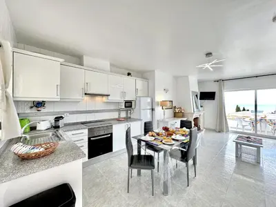 a kitchen and dining room with a table and chairs at Albufeira Tropical View 2 by Homing in Sesmarias