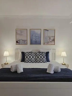 a bedroom with a large bed with four pictures on the wall at Brisa do Atlântico 201 in Albufeira