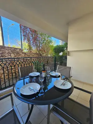 a table with plates and wine glasses on a balcony at Brisa do Atlântico 201 in Albufeira