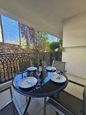 a table with plates and glasses on a balcony at Brisa do Atlântico 201 in Albufeira