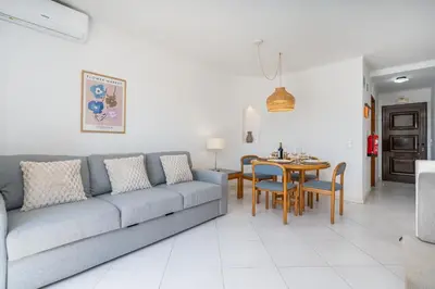 a living room with a couch and a table at Sunny Flat with a Balcony & Pool by HostWise in Albufeira