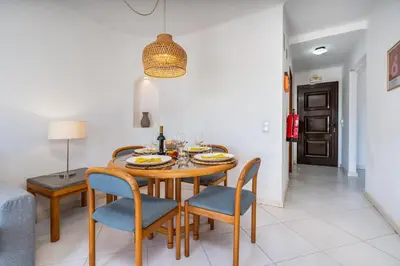a dining room with a table and chairs at Sunny Flat with a Balcony & Pool by HostWise in Albufeira