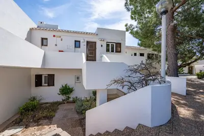 a white house with a staircase in front of it at Sunny Flat with a Balcony & Pool by HostWise in Albufeira