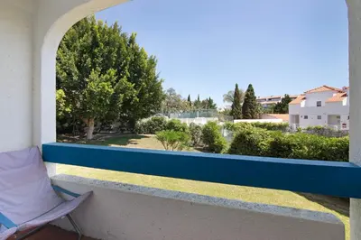 a balcony with a window with a view of a yard at Santiago’s Oura House in Albufeira