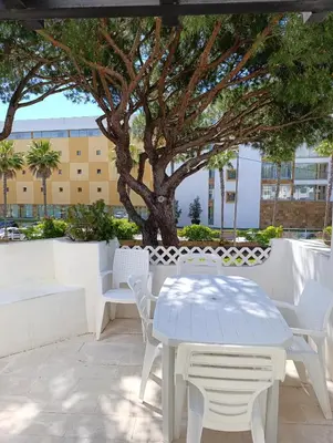 a white table and chairs on a patio with a tree at Balaia Golf Village 122 in Albufeira