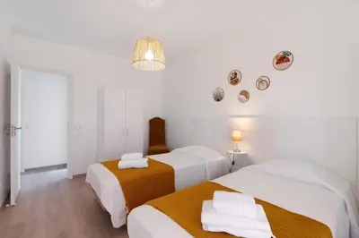 two beds in a room with white walls at Justo's House in Faro