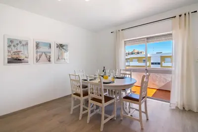 a dining room with a table and chairs and a window at Justo's House in Faro
