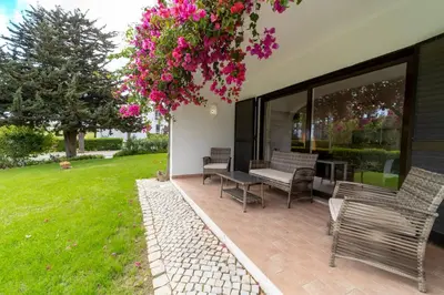 a bedroom with a large bed and a red couch at Apt 77 - São Rafael by HelloVacations in Albufeira