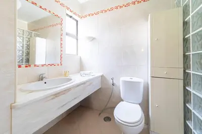 a bathroom with a toilet and a sink and a mirror at Apt 77 - São Rafael by HelloVacations in Albufeira