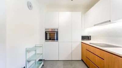 a kitchen with white walls and wooden cabinets at Modern Studio with Balcony in Salgados by Lovelystay in Guia