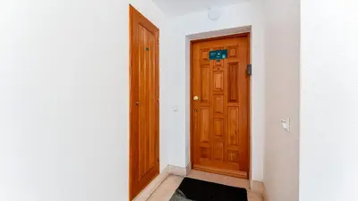 an empty hallway with a wooden door and a rug at Modern Studio with Balcony in Salgados by Lovelystay in Guia