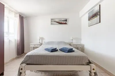 a white bedroom with a bed with blue towels on it at Maison A Quinta V2A 5 Personnes in Ferreiras