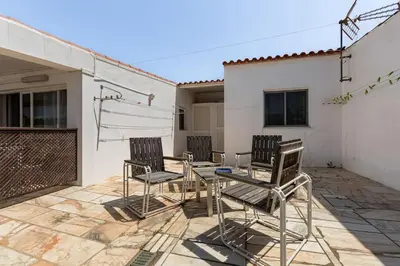 a patio with three chairs and a table on a patio at Maison A Quinta V2B 7 Personnes in Ferreiras