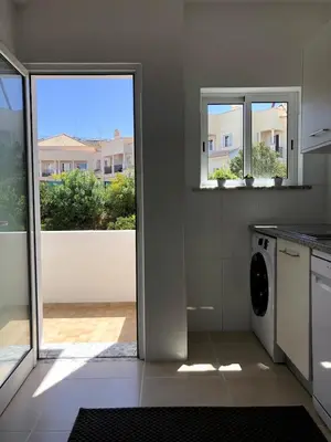 a chair on a balcony with a view of a street at Apt H - Beach Village in Olhos de Água