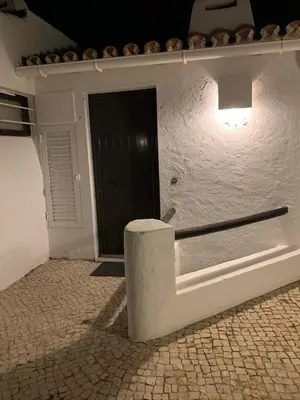 a white building with a black door and a light at Açoteias Falésia Studio Apartment in Olhos de Água