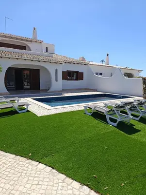 a house with a yard with chairs and a swimming pool at Villa Inês in Guia