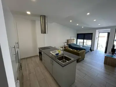a kitchen and living room with a sink and a couch at Casa Susana in Faro